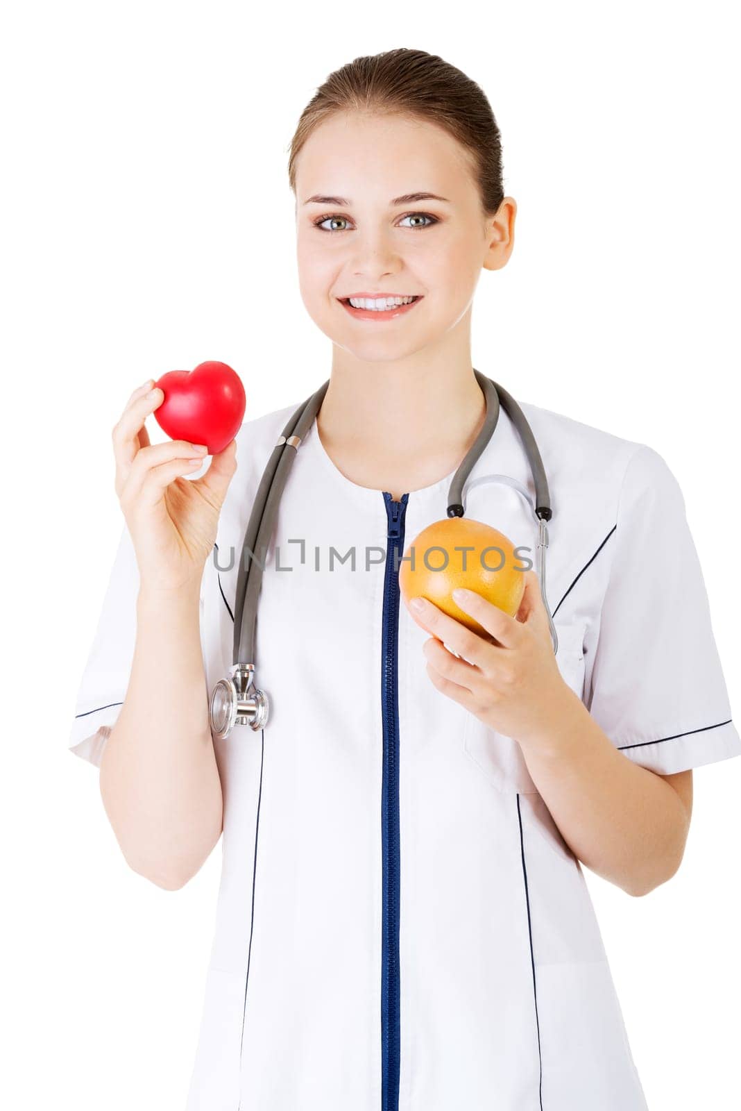 Female doctor holding healthy grapefruit and red heart. Isolated on white.