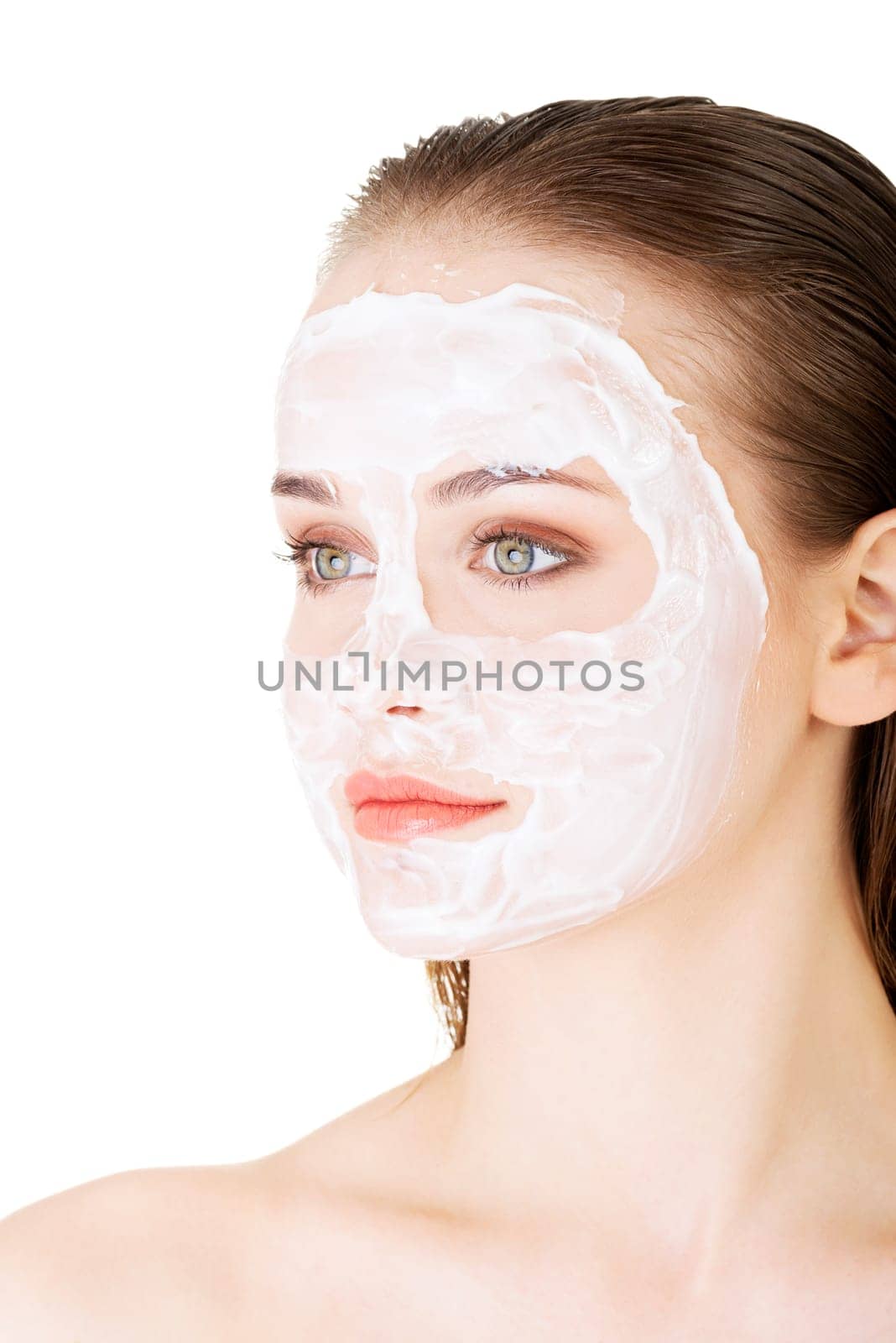 Beautiful woman with clay facial mask, isolated on white