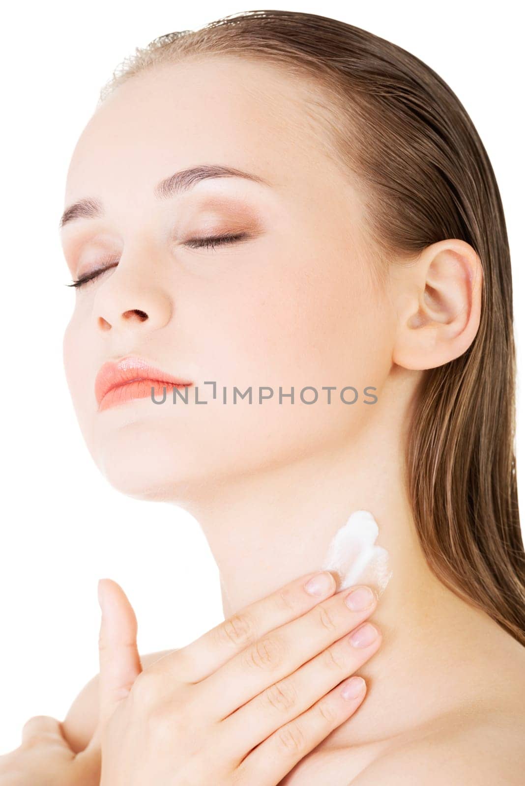 Beautiful woman with healthy skin applying cosmetic cream on a clean fresh face