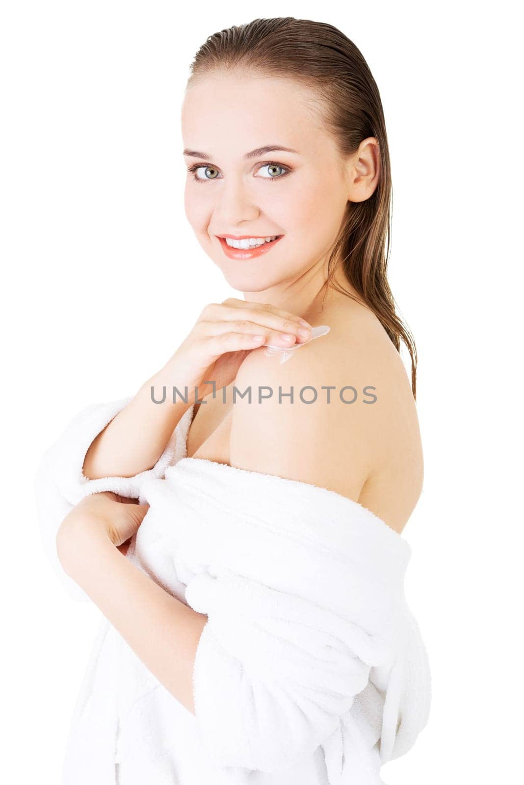 Beautiful woman with healthy skin applying cosmetic cream on a clean fresh face