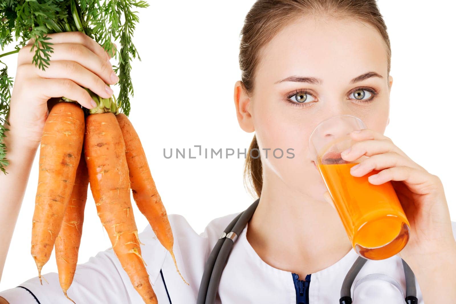 Female doctor holding healthy carrots and juice. Isolated on white.