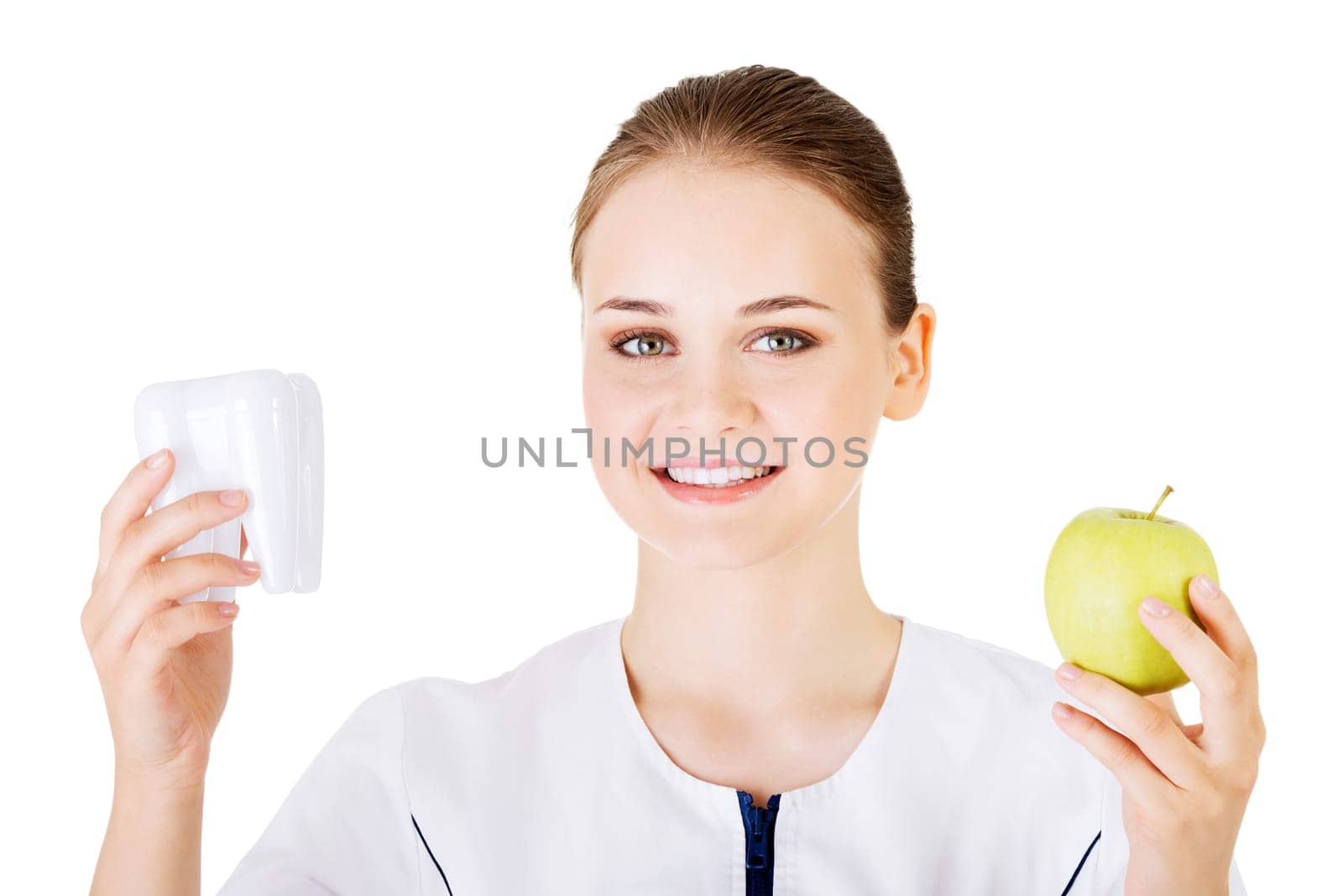 Female dentist with green apple and big tooth. Isolated on white