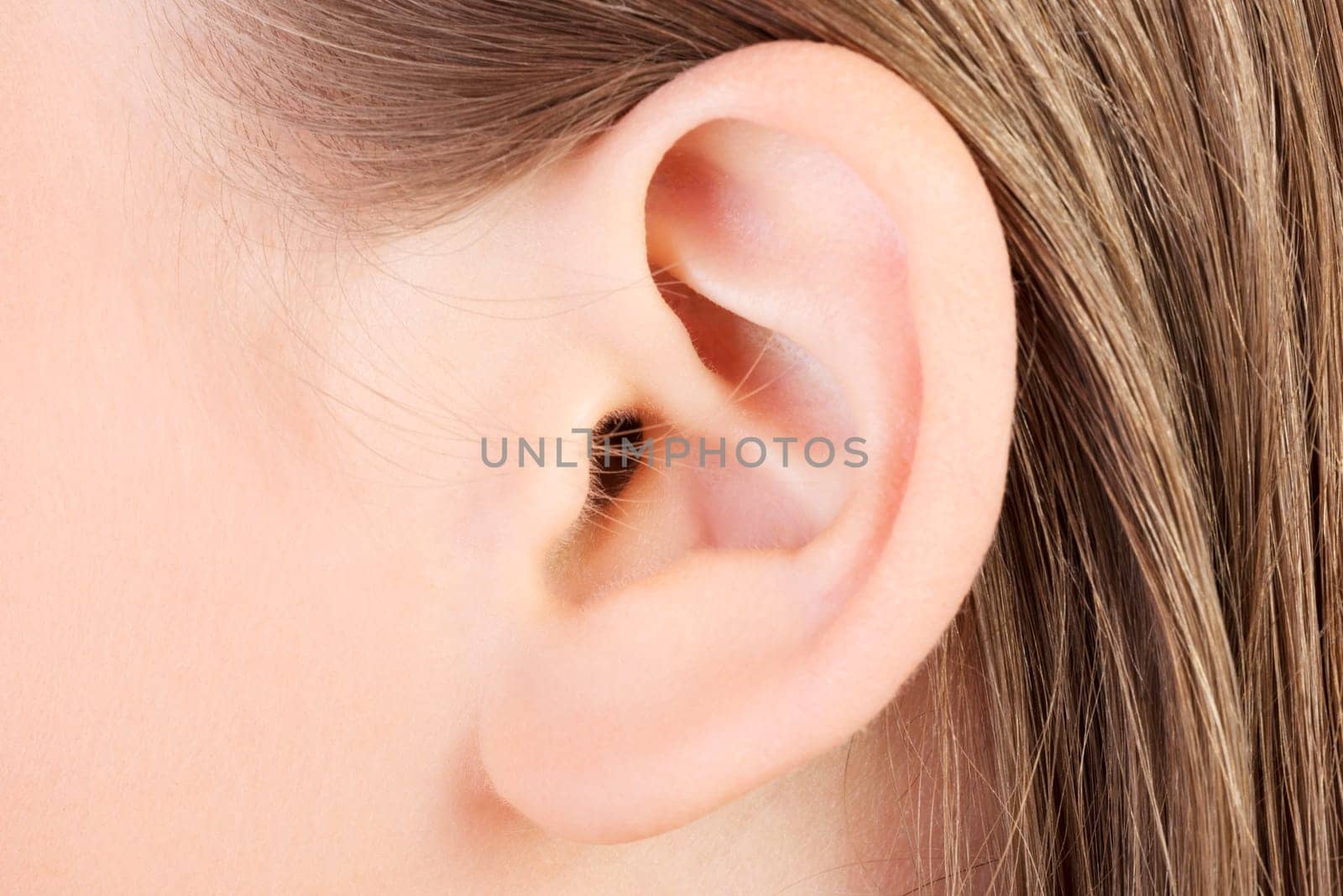 Young caucasian woman ear closeup.