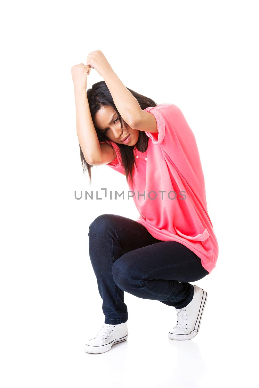 Scared young woman afraid of something above her, isolated on white