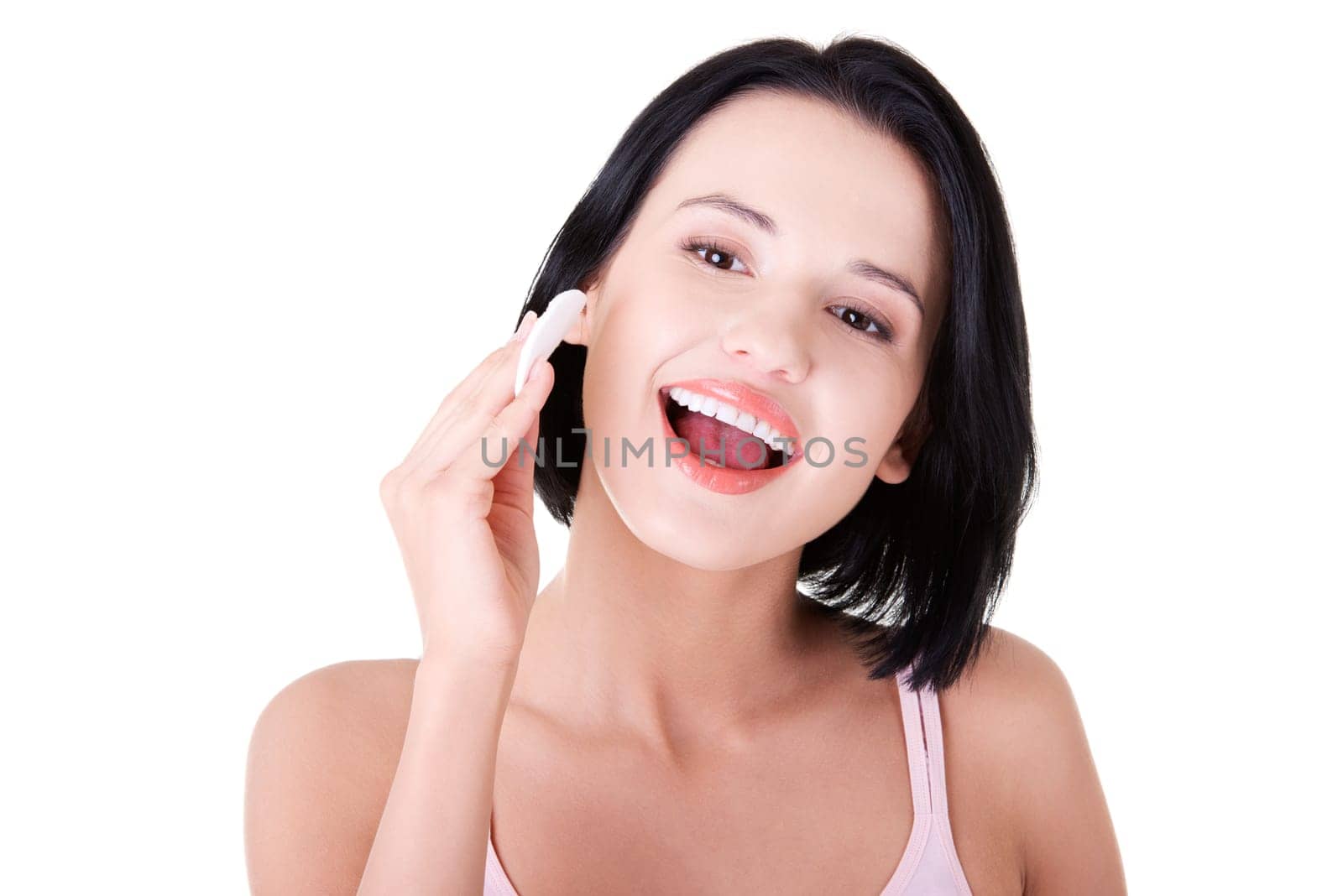 Young beautiful caucasian woman using a cotton pad to remove her make-up. Isolated on white