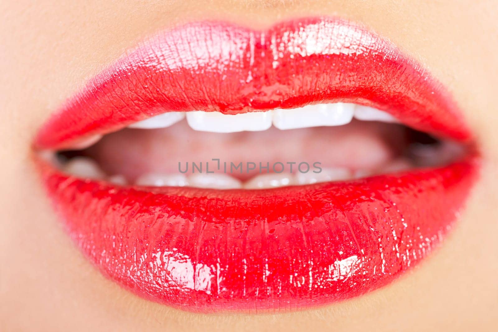Closeup shoot of beautiful lips of woman with red lipstick and gloss.
