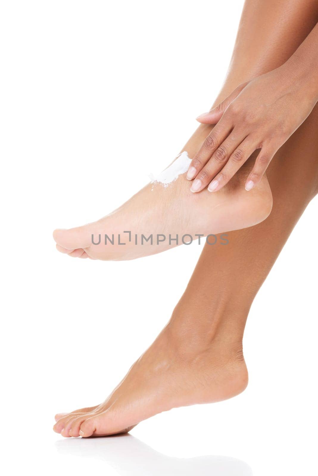 Female hands treating feet with moisturizing cream, isolated on white