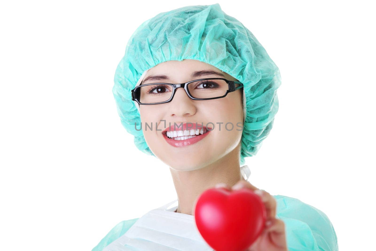 Smiling female doctor or nurse in surgical clothes holding red heart