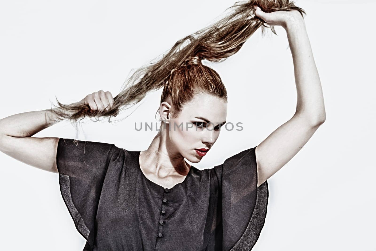 Beautifull young blond woman in the studio holding up her hair