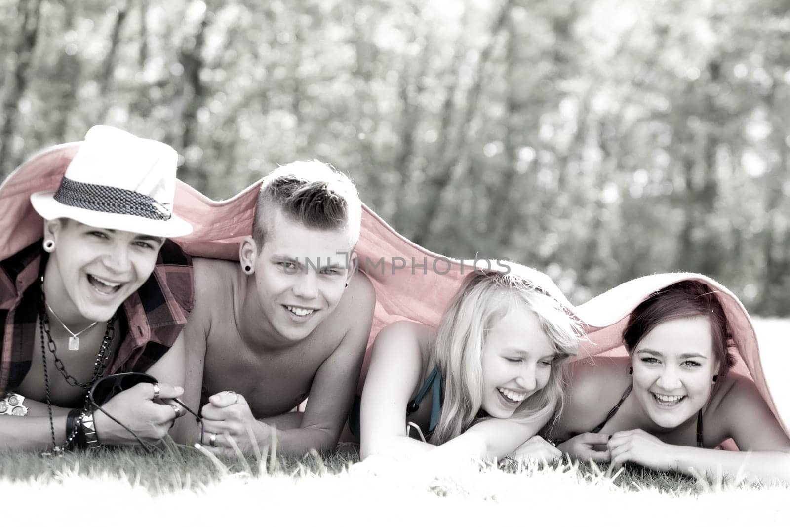 Four teenagers are hiding under a blanket
