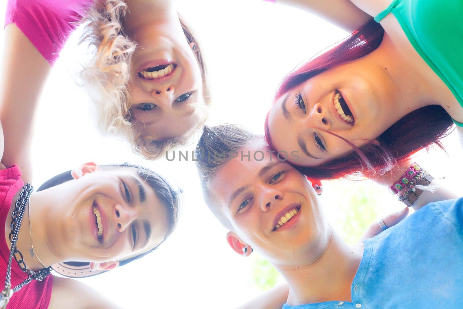 Four teenagers are having fun and looking downstrairs