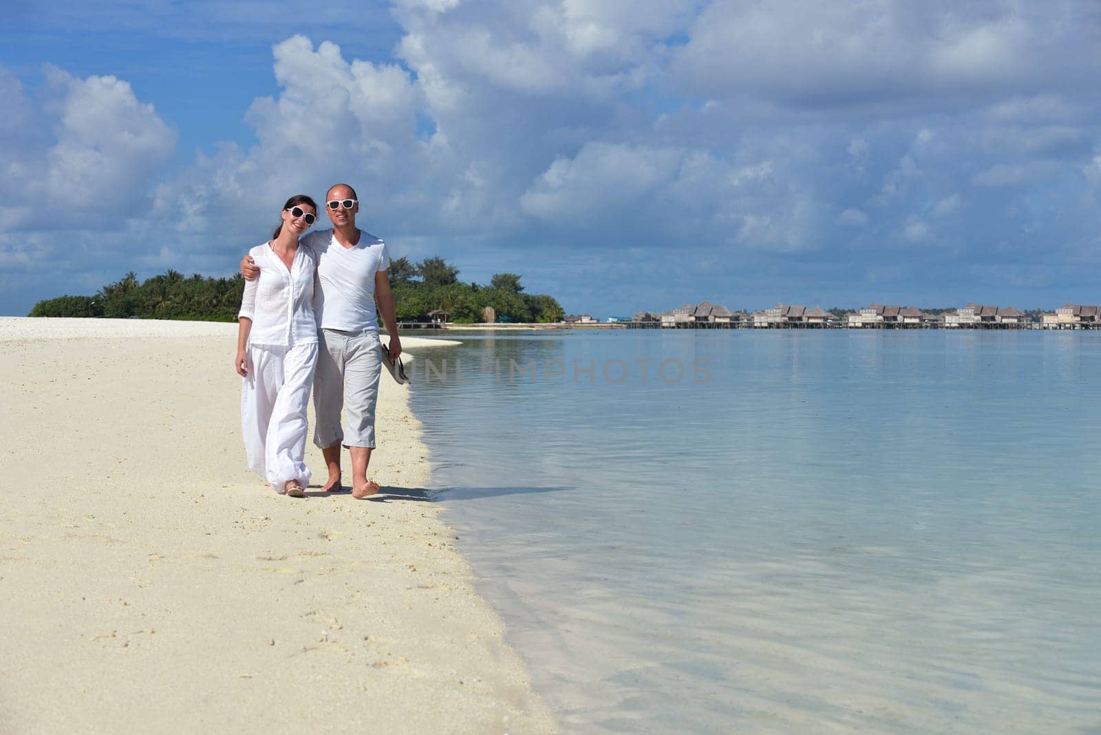 happy young couple have fun and relax at summer vacation on background maldives travel location and beautiful white sand beach