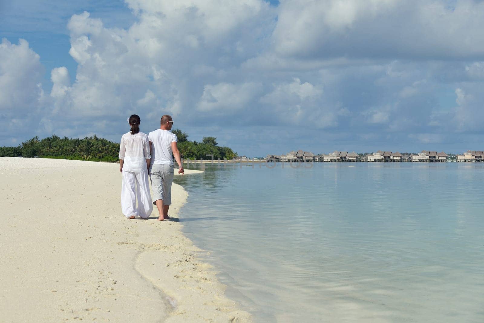 happy young couple have fun and relax at summer vacation on background maldives travel location and beautiful white sand beach