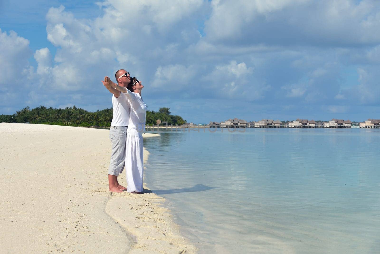 happy young couple have fun and relax at summer vacation on background maldives travel location and beautiful white sand beach