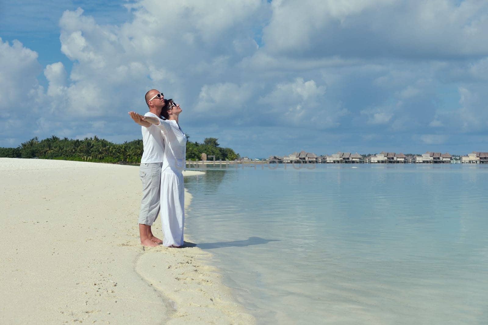 happy young couple have fun and relax at summer vacation on background maldives travel location and beautiful white sand beach