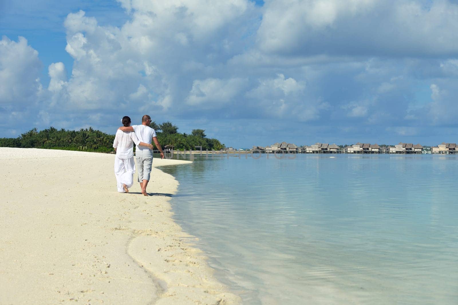 happy young couple have fun and relax at summer vacation on background maldives travel location and beautiful white sand beach