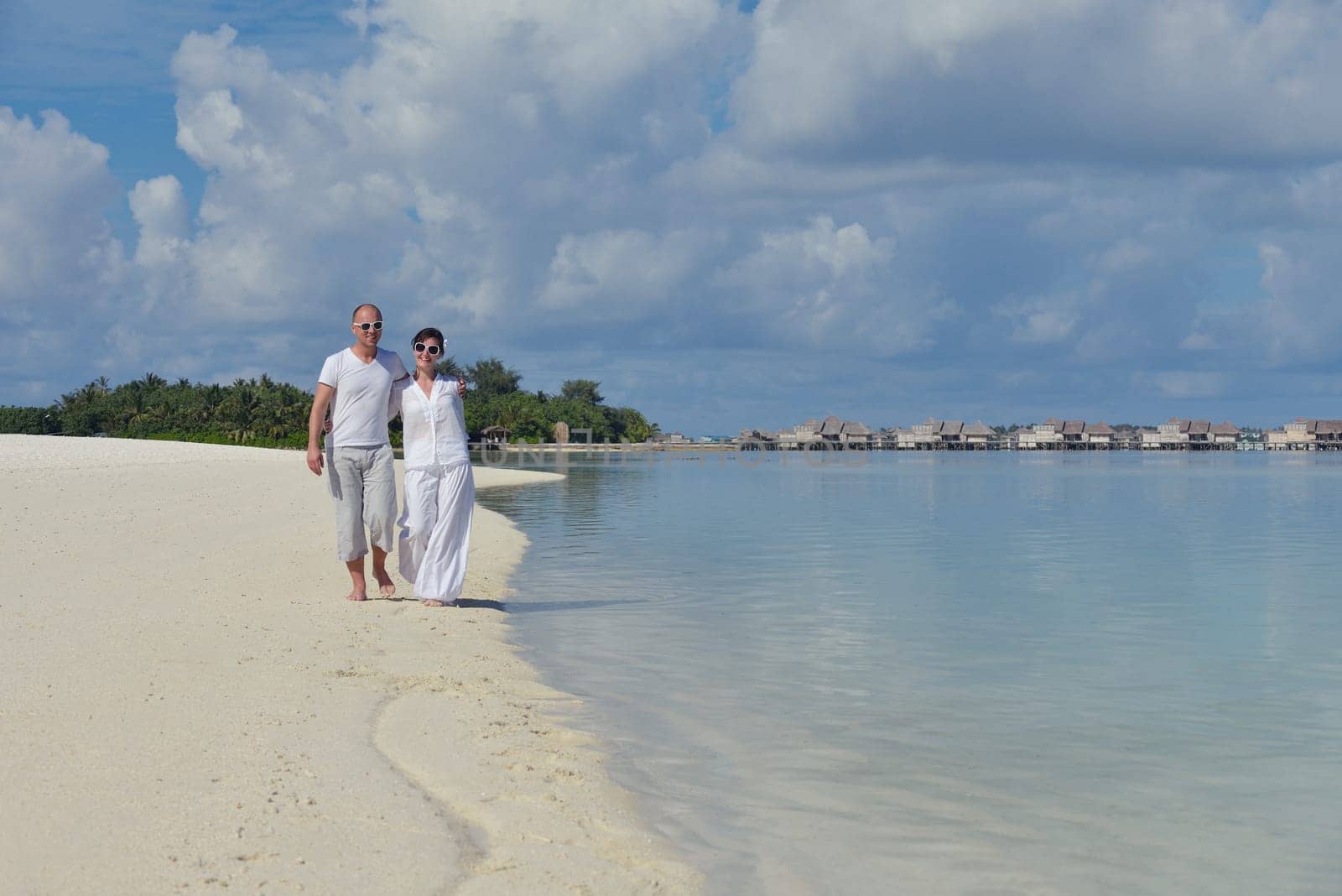 happy young couple have fun and relax at summer vacation on background maldives travel location and beautiful white sand beach