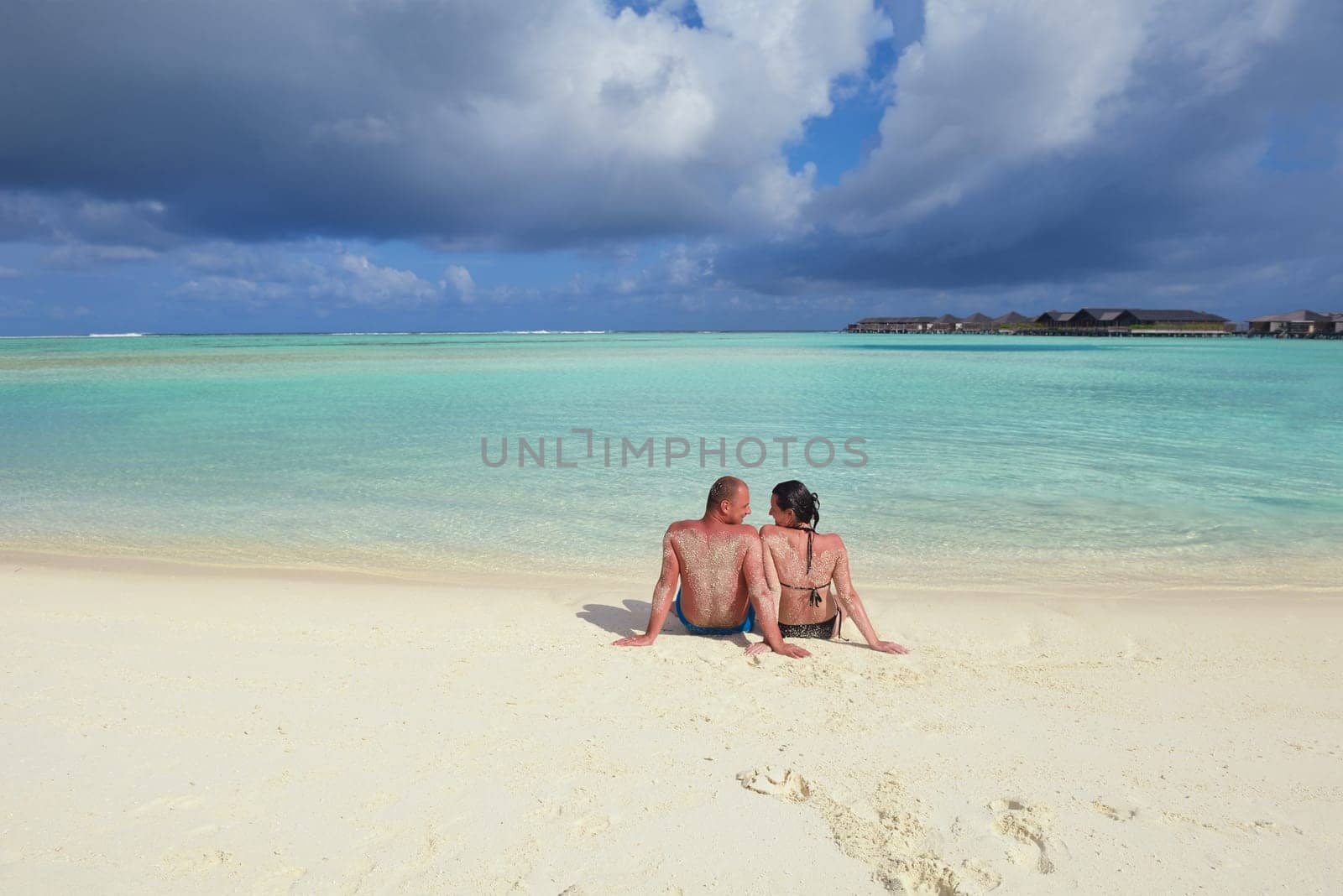 happy young couple have fun and relax at summer vacation on background maldives travel location and beautiful white sand beach