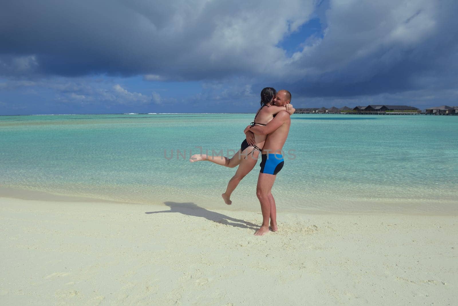 happy young couple have fun and relax at summer vacation on background maldives travel location and beautiful white sand beach
