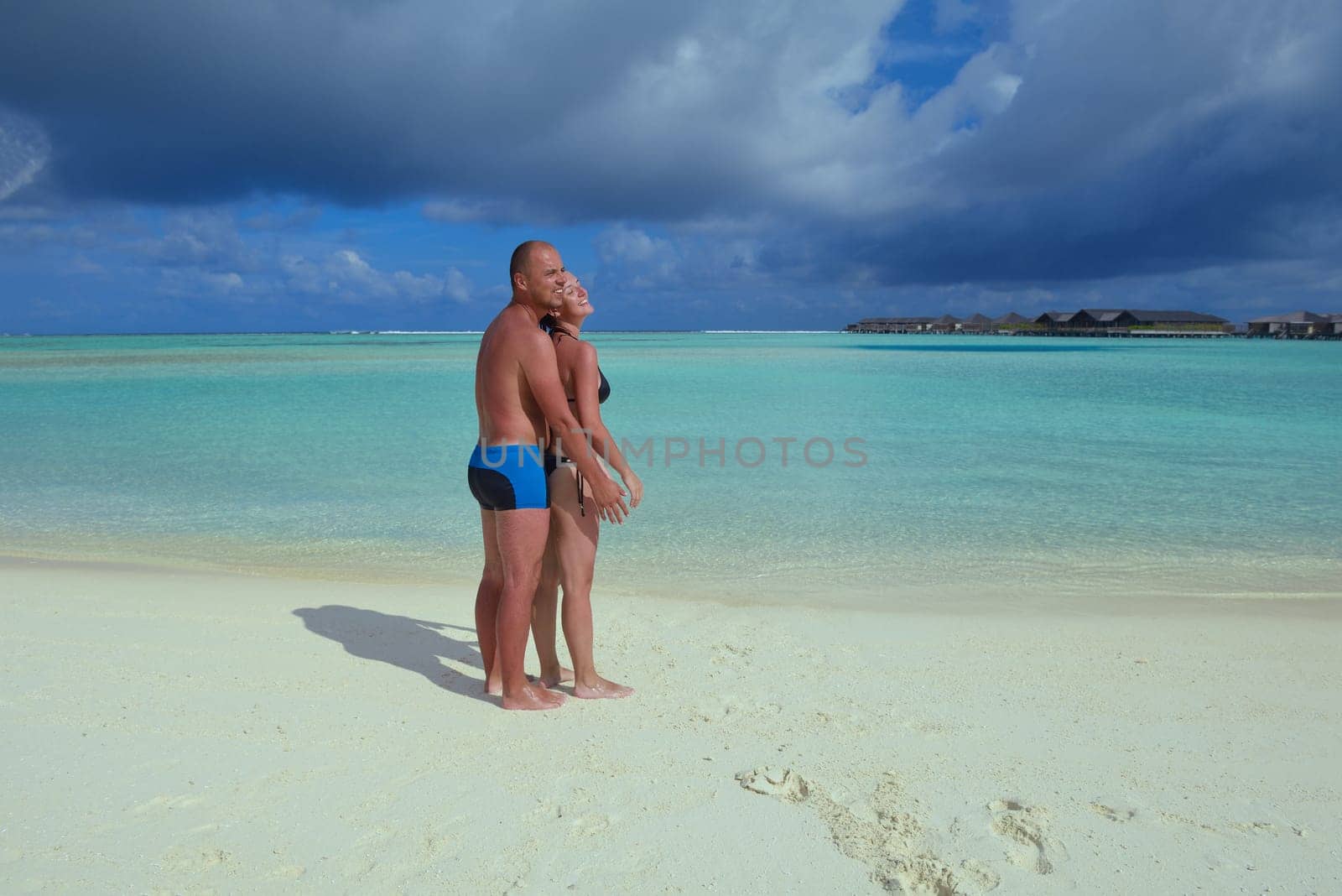 happy young couple have fun and relax at summer vacation on background maldives travel location and beautiful white sand beach