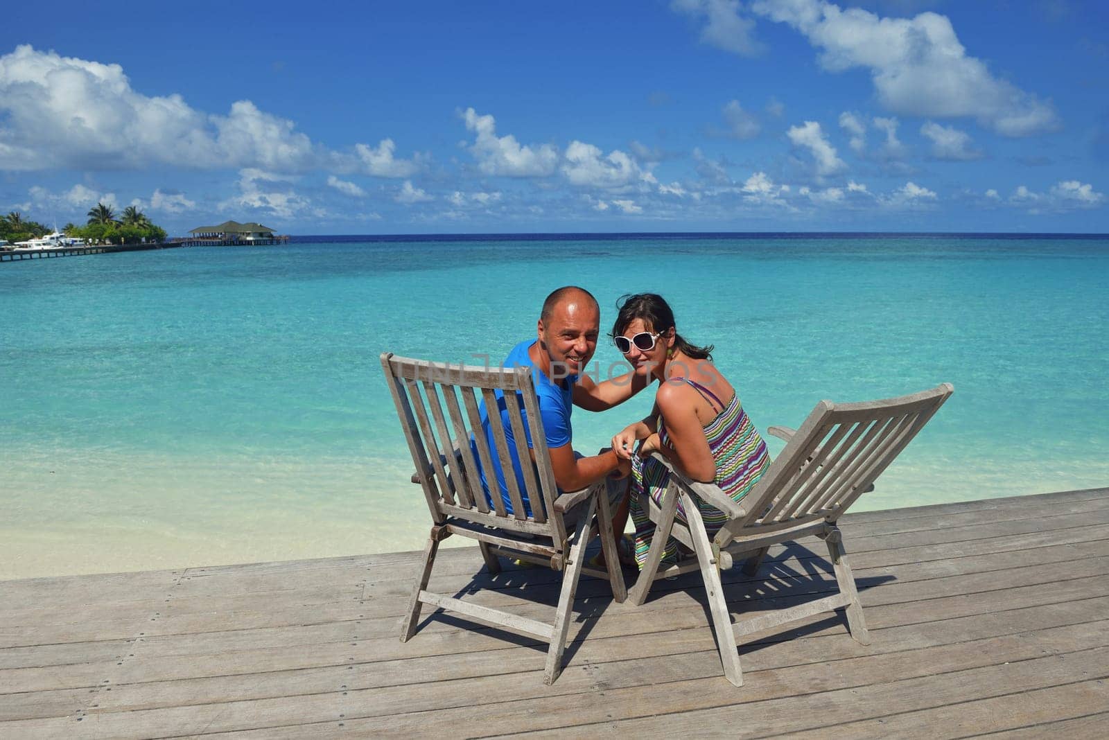 happy young couple have fun and relax at summer vacation on background maldives travel location and beautiful white sand beach