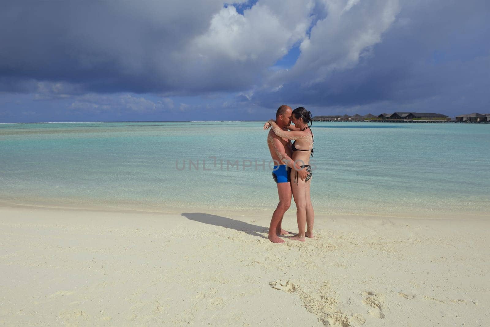 happy young couple have fun and relax at summer vacation on background maldives travel location and beautiful white sand beach