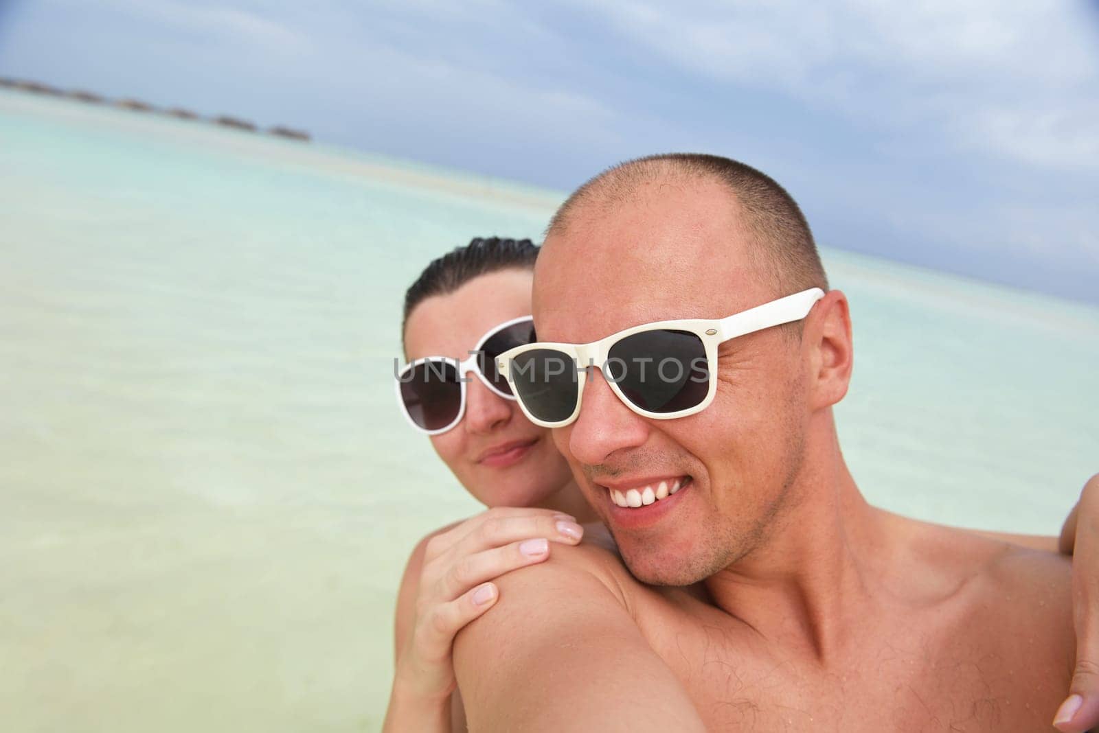 happy young couple have fun and relax at summer vacation on background maldives travel location and beautiful white sand beach