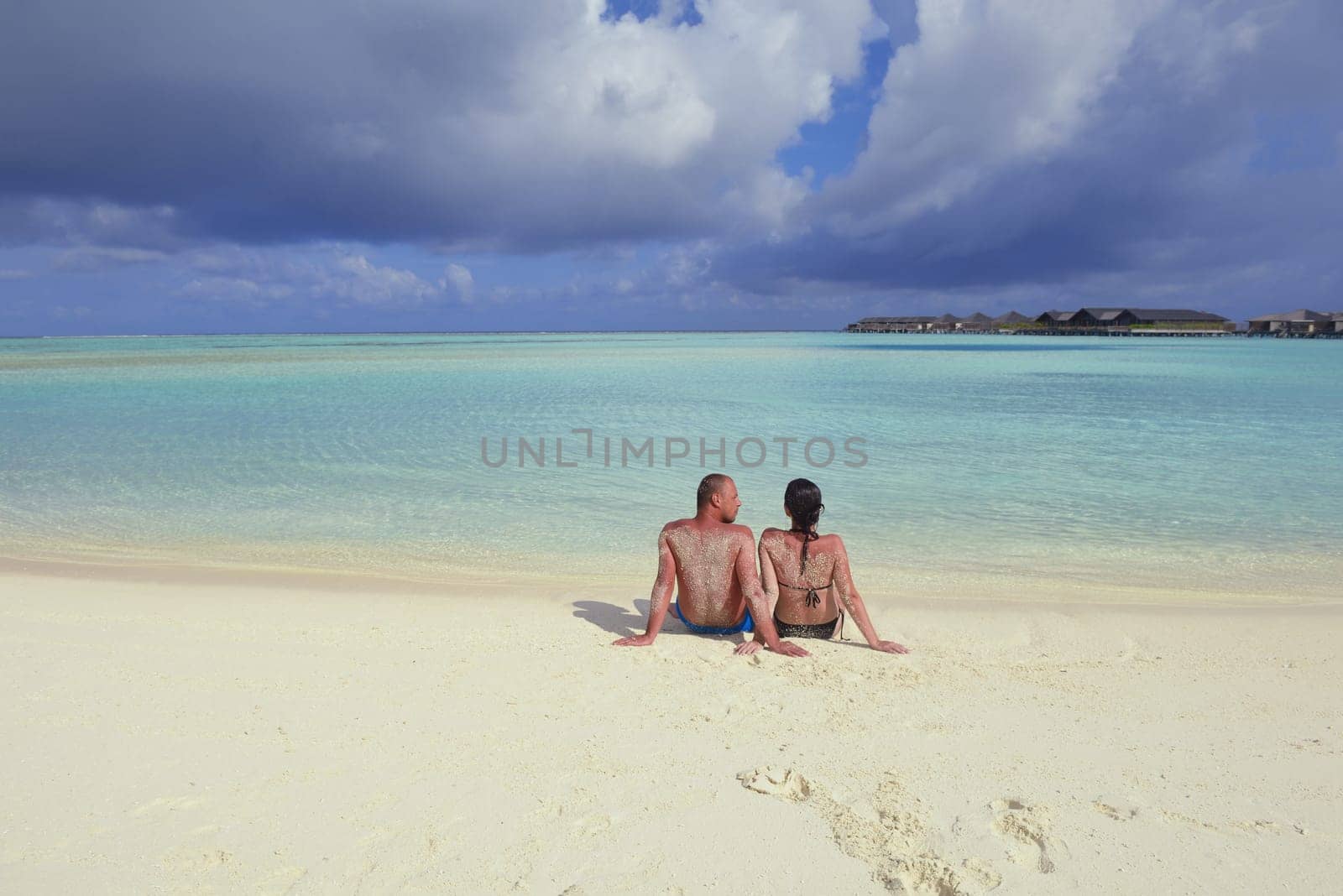happy young couple have fun and relax at summer vacation on background maldives travel location and beautiful white sand beach