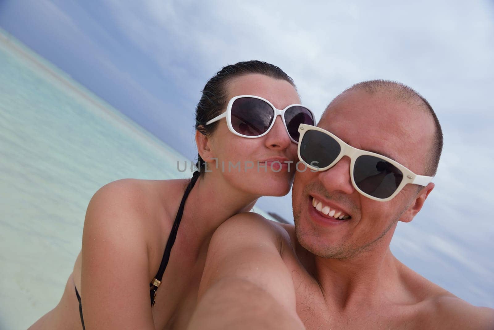 happy young couple have fun and relax at summer vacation on background maldives travel location and beautiful white sand beach