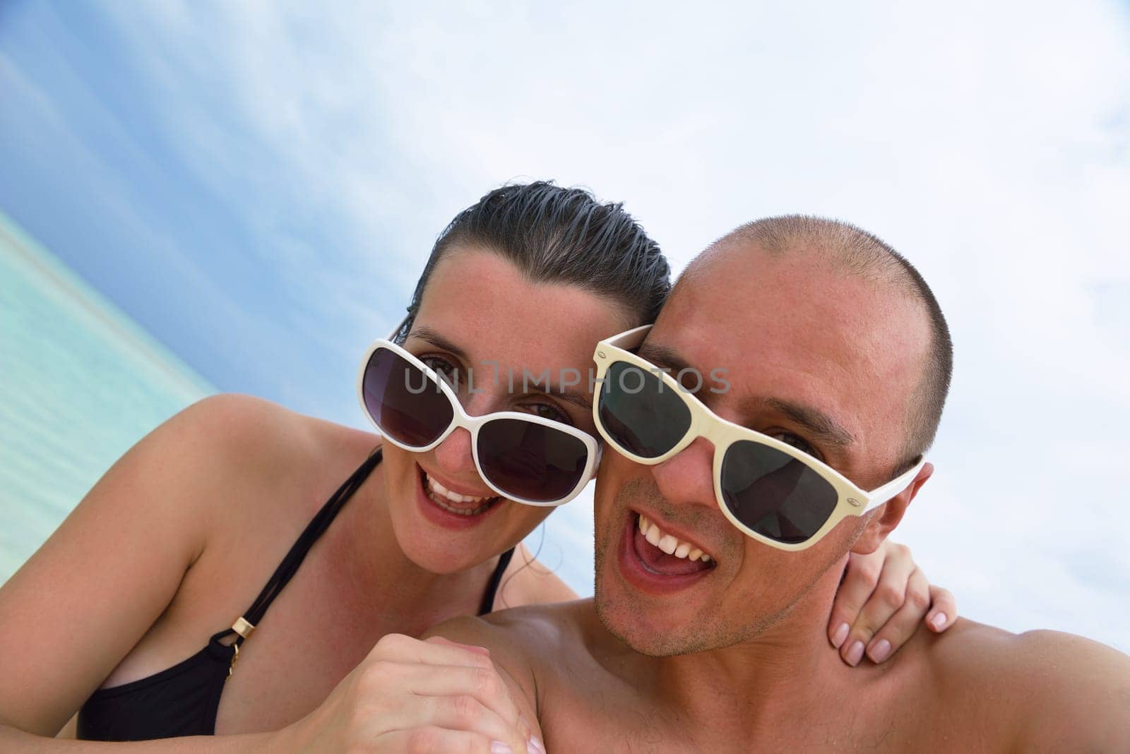 happy young couple have fun and relax at summer vacation on background maldives travel location and beautiful white sand beach