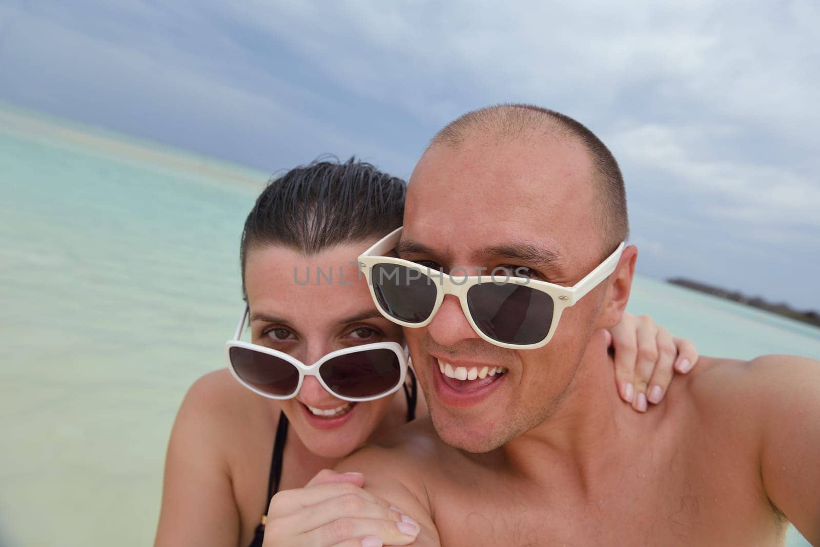happy young couple have fun and relax at summer vacation on background maldives travel location and beautiful white sand beach