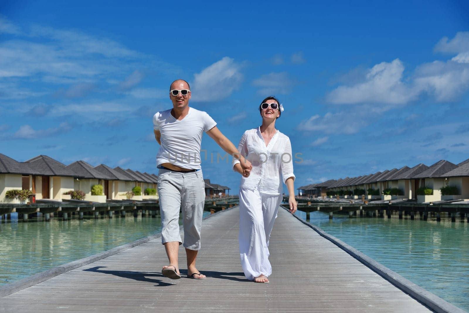 happy young couple have fun and relax at summer vacation on background maldives travel location and beautiful white sand beach