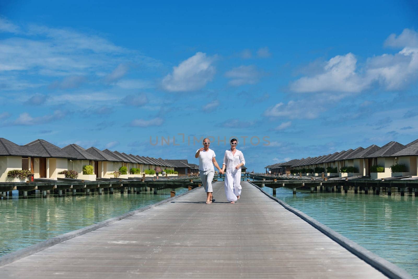 happy young couple have fun and relax at summer vacation on background maldives travel location and beautiful white sand beach