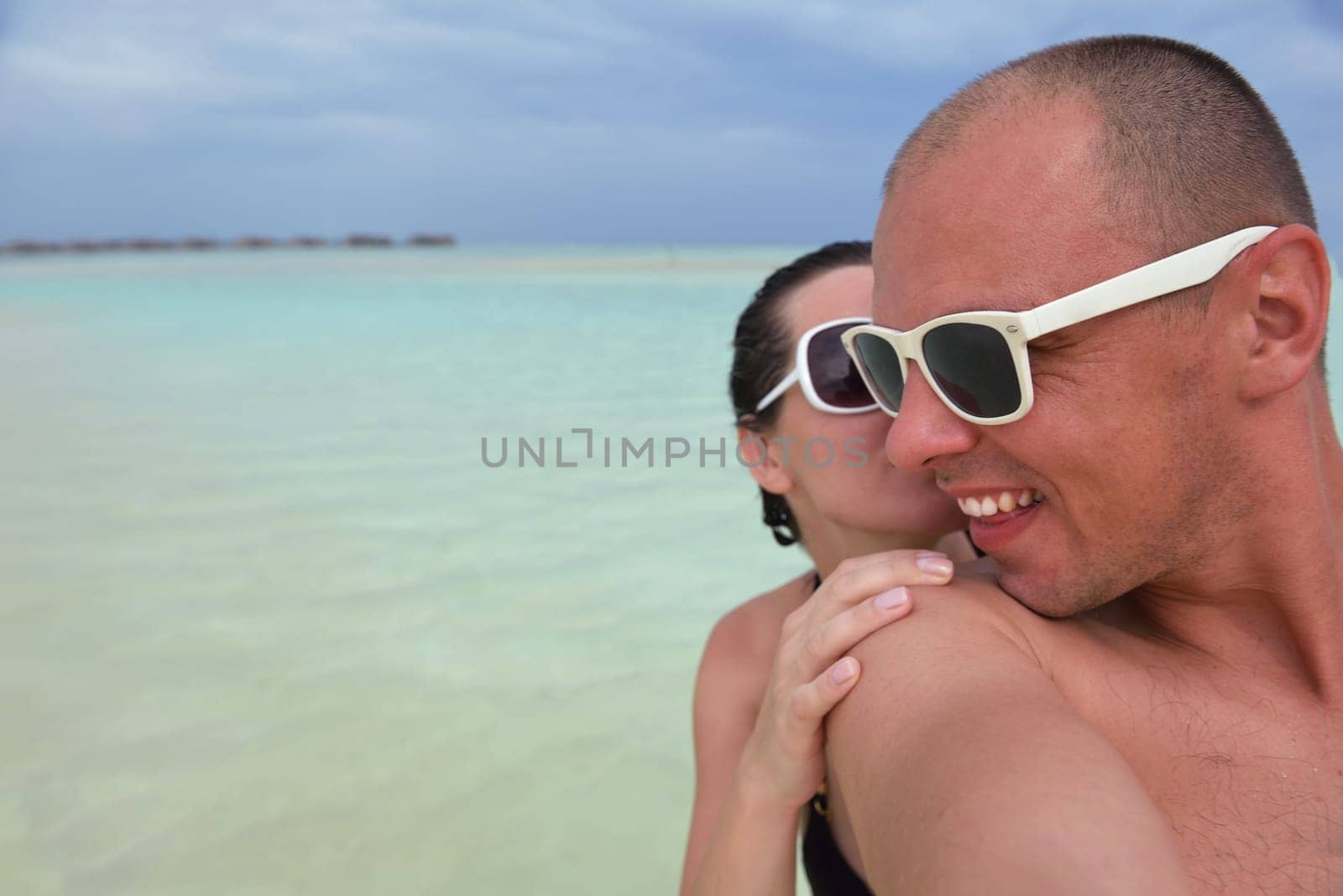 happy young couple have fun and relax at summer vacation on background maldives travel location and beautiful white sand beach