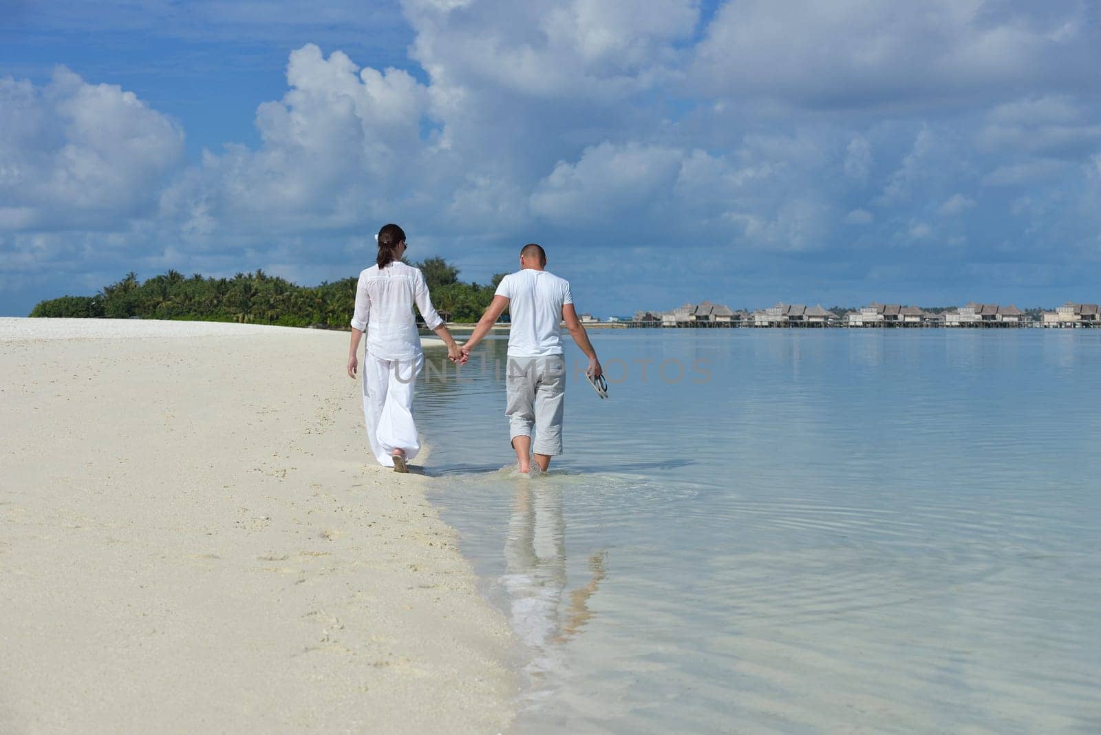 happy young couple have fun and relax at summer vacation on background maldives travel location and beautiful white sand beach