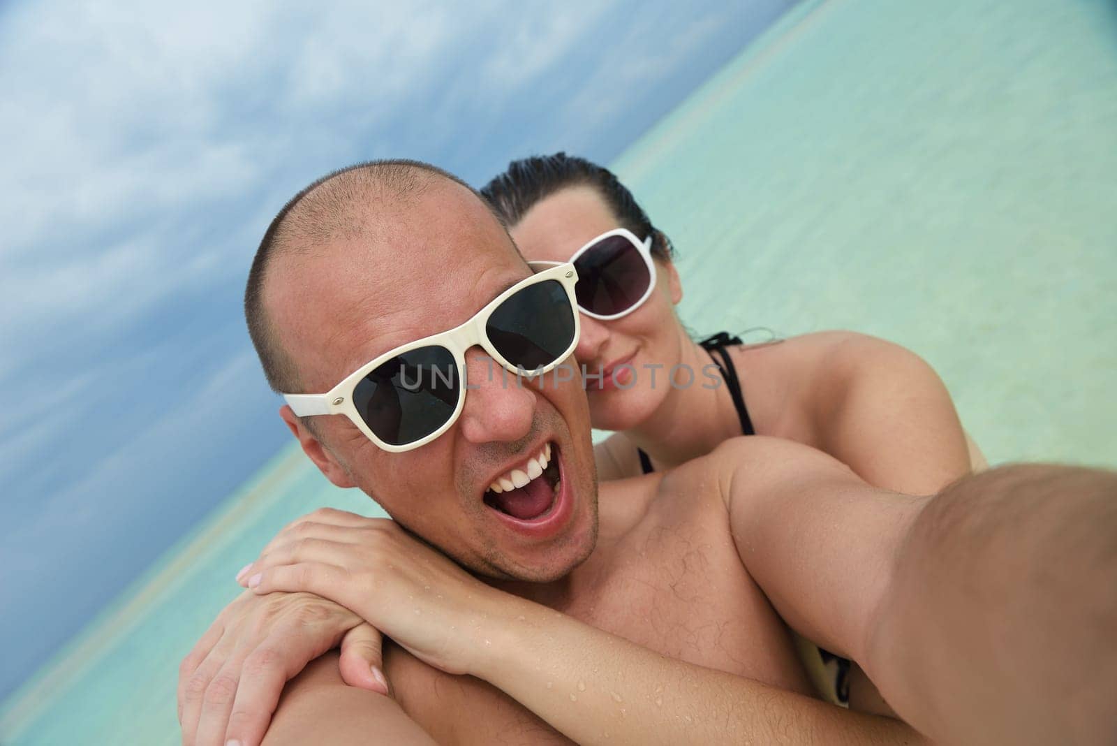 happy young couple have fun and relax at summer vacation on background maldives travel location and beautiful white sand beach