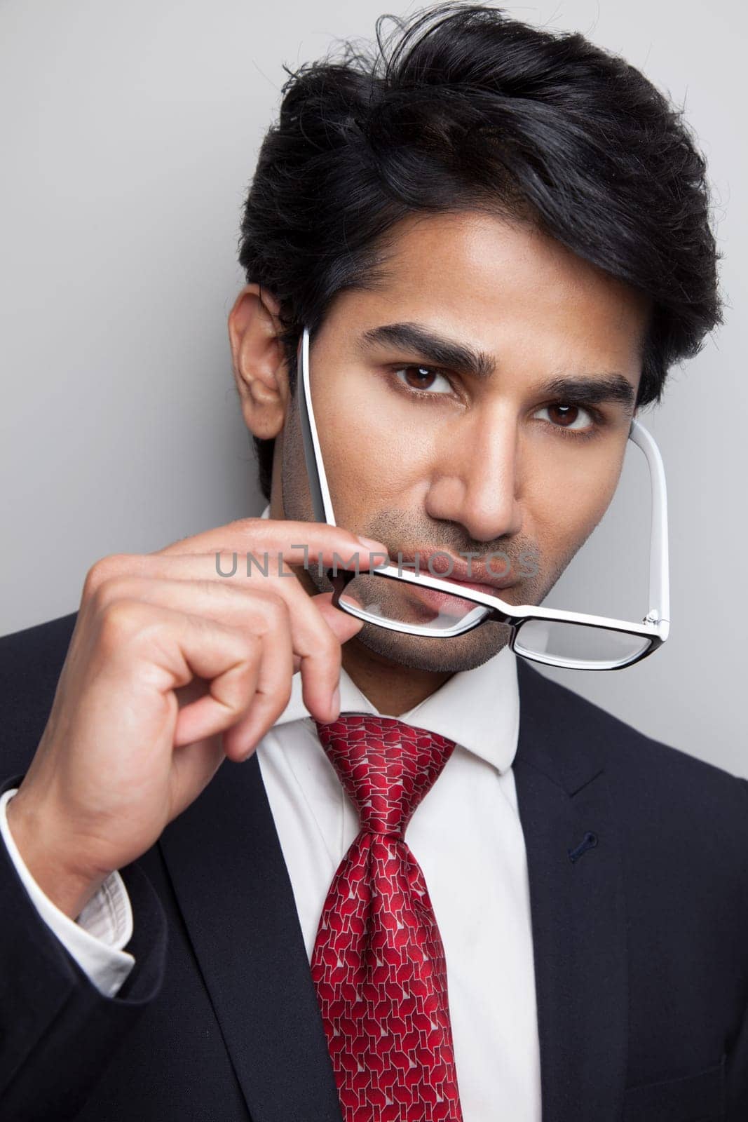 Confident businessman taking of glasses
