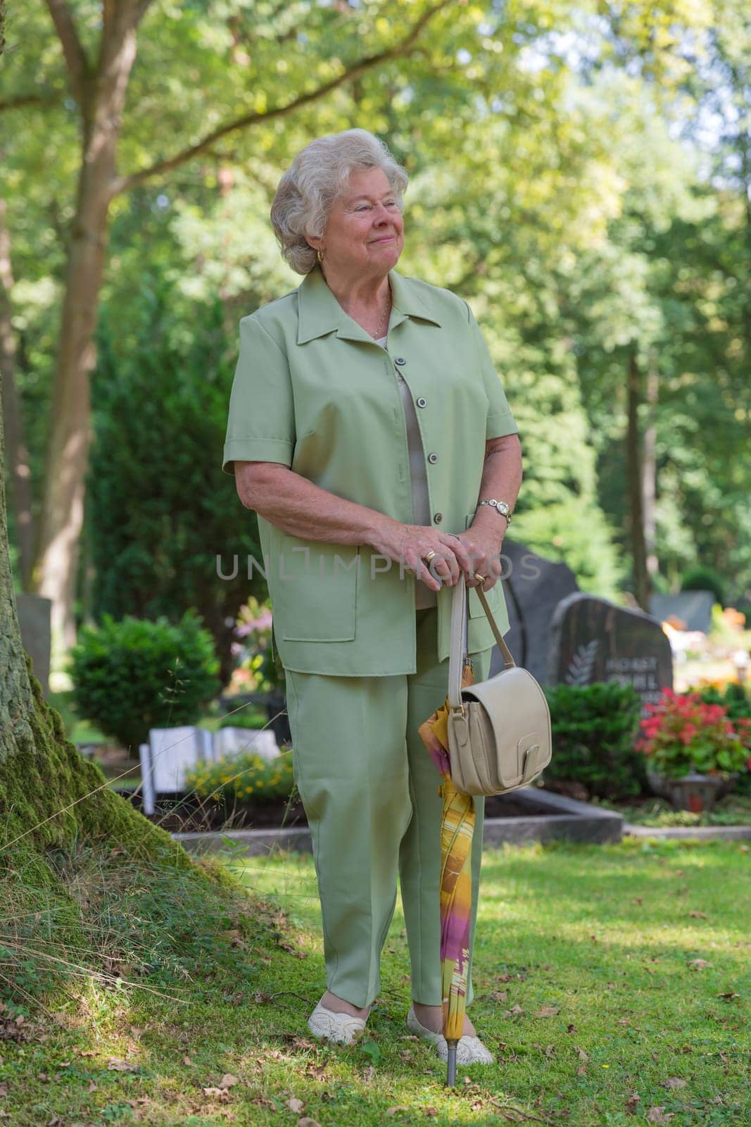 Elderly lady walks across a Fiedhof