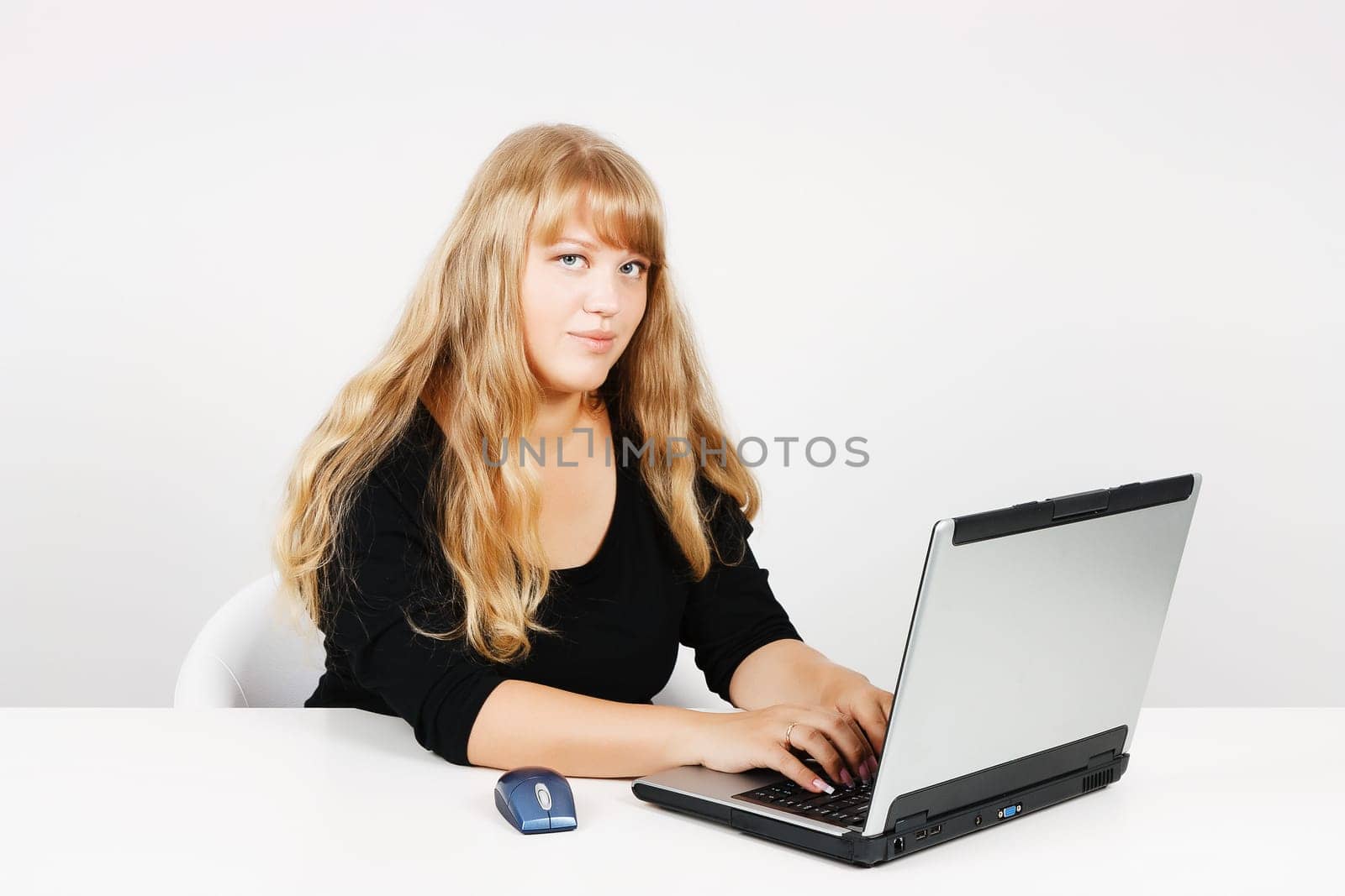 Blond girl with laptop in the office