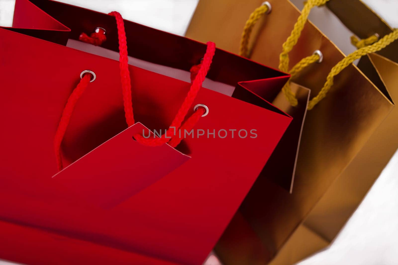 Two gift bags, one red and one gold, isolated.