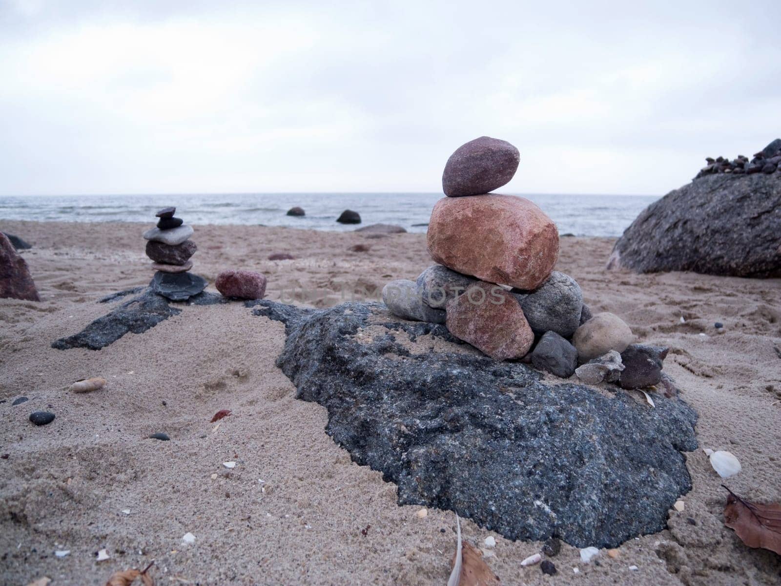 superimposed pebbles on the North Sea coast under cloudy skies in frog perspective