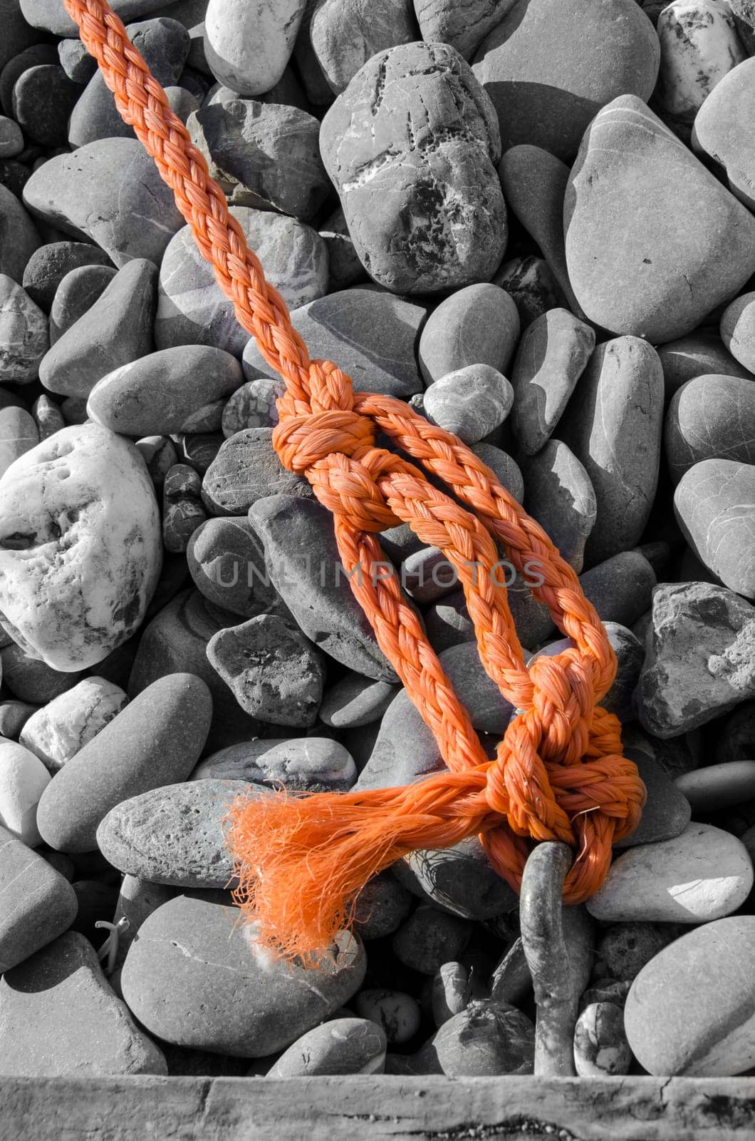 orange rope on the beach of gray stones