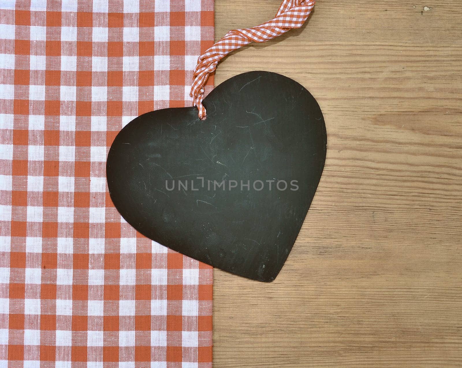 a black heart red rarized bow on wooden background