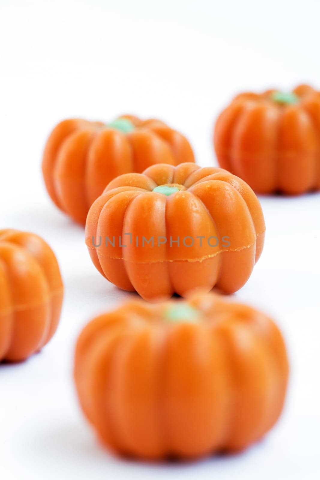 Colorful group of halloween candy in shape of pumpkins on white background. Also useful as autumn concept.