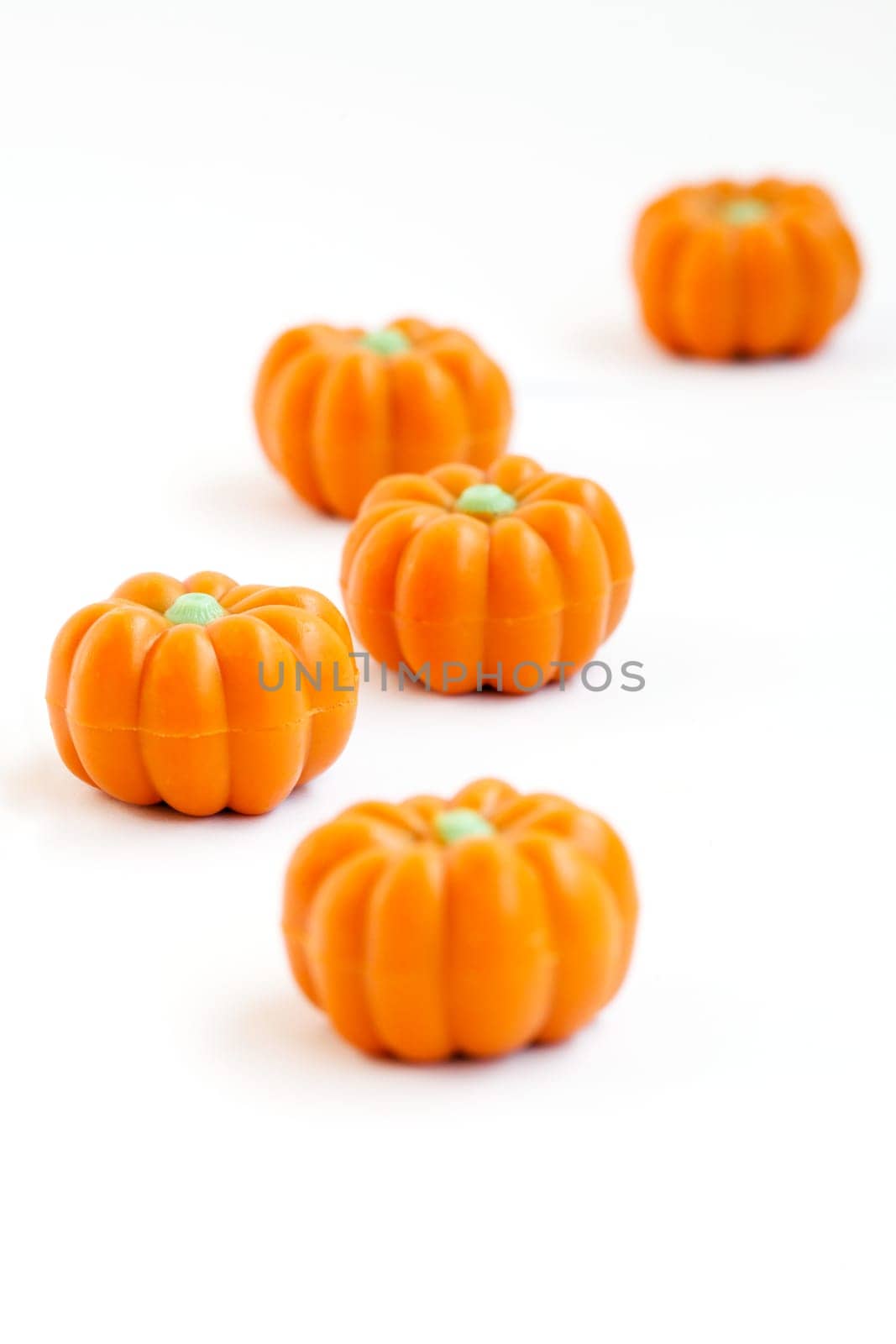 Colorful group of halloween candy in shape of pumpkins on white background. Also useful as autumn concept.