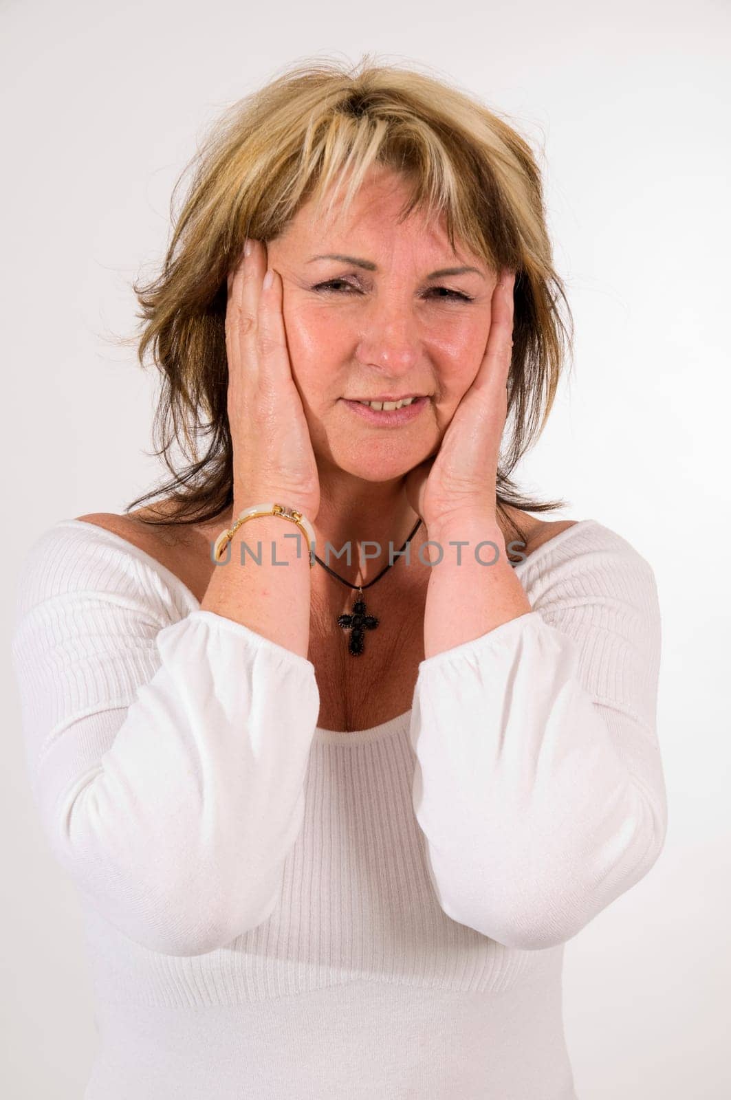 Upper body shot of a middle-aged woman touching her temples in pain