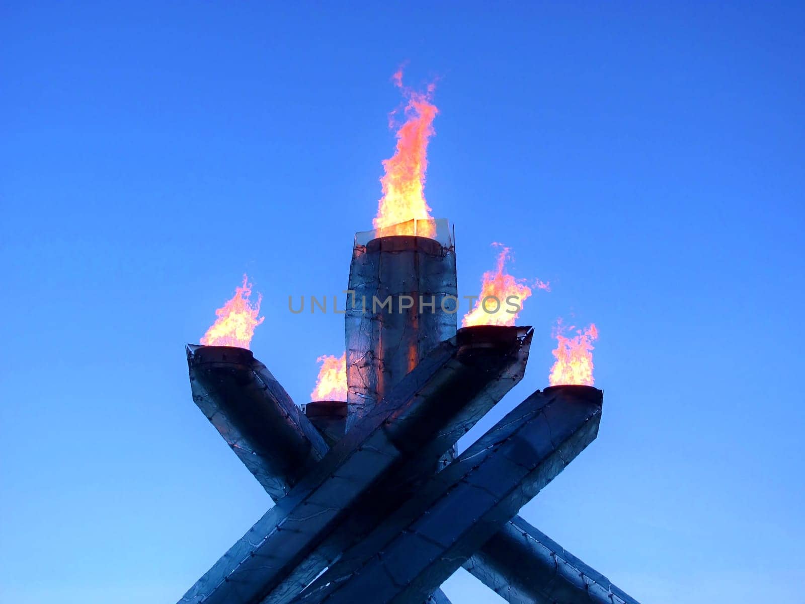 Contemporary fire torches burning over a cloudless blue sky