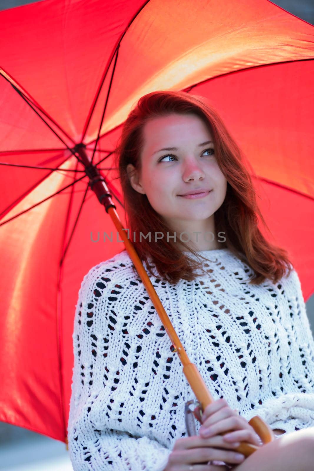 Happy young woman with open umbrella at hand