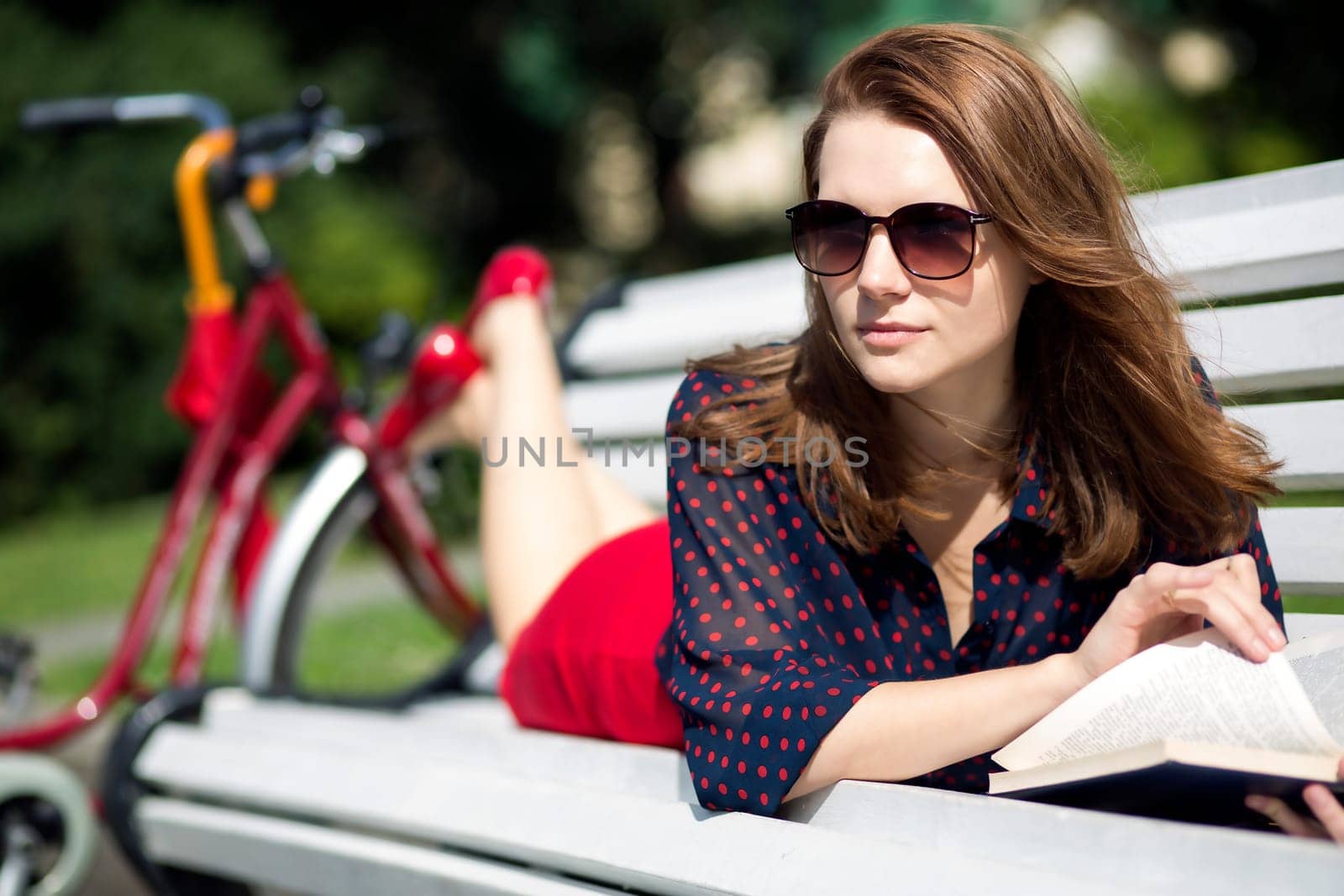 Young woman lying on bench and notise something