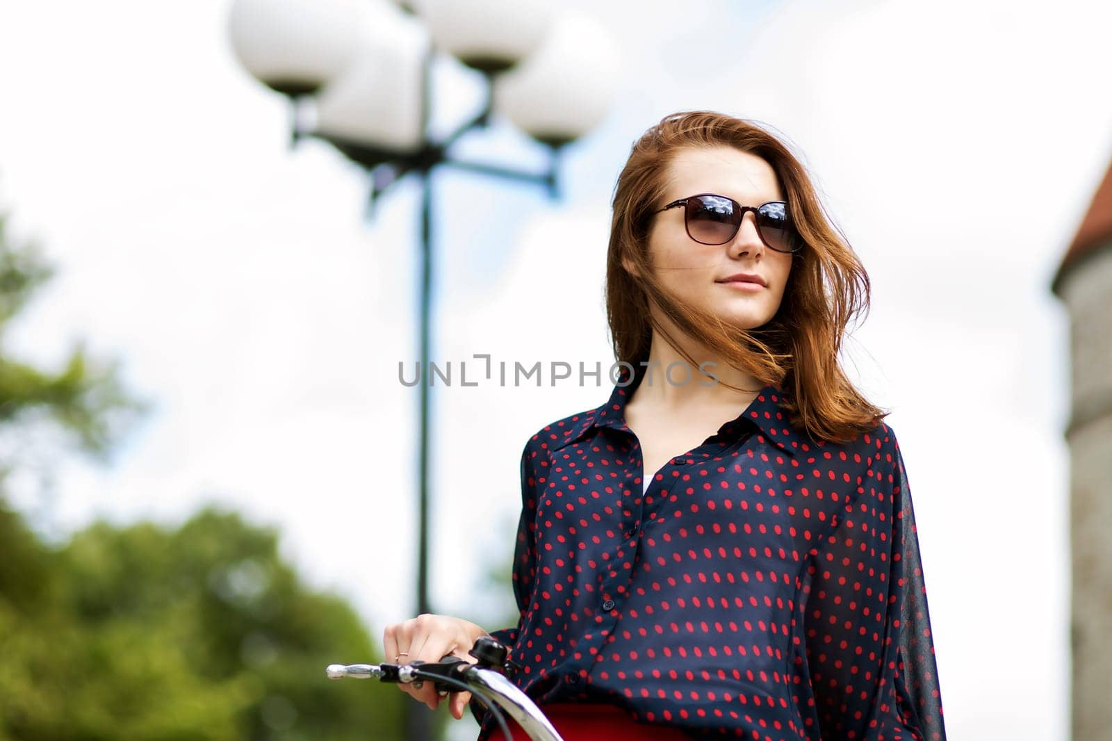 Woman on bicycle in sunglasses looking at far